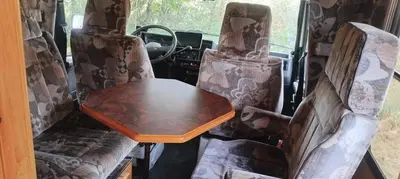a table in the back of a van with chairs at Le camping-car de la Gardié in Vielmur-sur-Agout