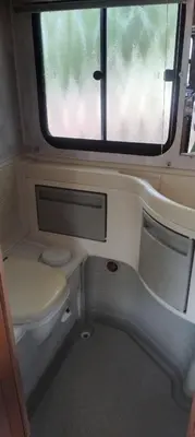 a small bathroom with a toilet and a window at Le camping-car de la Gardié in Vielmur-sur-Agout