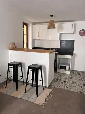 a kitchen with two stools and a counter with a microwave at Hyper centre de Narbonne in Narbonne