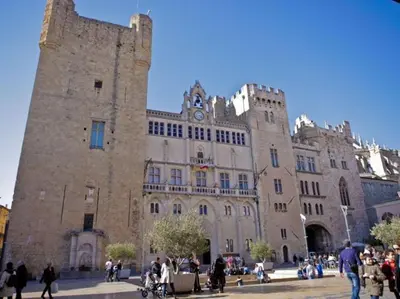 a large stone building with a clock tower at Hyper centre de Narbonne in Narbonne