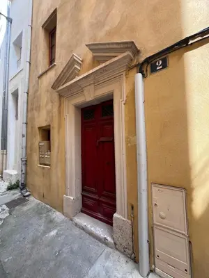 a red door on the side of a building at Hyper centre de Narbonne in Narbonne
