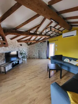 a living room with a couch and a tv at Maison de village Olonzac in Olonzac
