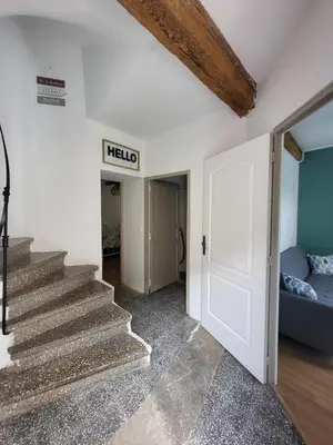 a hallway with stairs and a sign that reads hello at Maison de village Olonzac in Olonzac