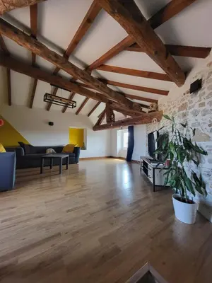 a large living room with wooden floors and exposed beams at Maison de village Olonzac in Olonzac
