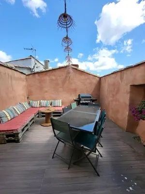 a patio with a table and chairs on a roof at Maison de village Olonzac in Olonzac