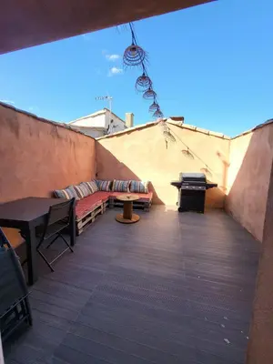 a balcony with benches and tables on a building at Maison de village Olonzac in Olonzac