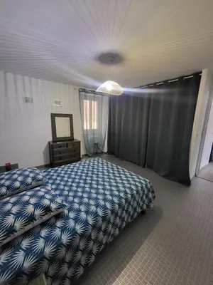 a bedroom with a bed with a blue comforter at Maison de village Olonzac in Olonzac