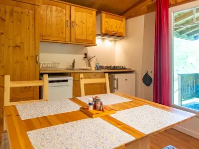 a kitchen with a wooden table and a table and chairs at Chalet 6 personnes avec Terrasse - API-1-52-233 in Fenouillet
