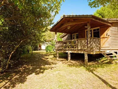 a wooden cabin with a porch in a yard at Chalet 6 personnes avec Terrasse - API-1-52-233 in Fenouillet