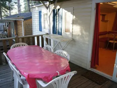 a pink table and chairs on the porch of a house at Mobil home confortable avec terrasse à Sournia - API-1-52-319 in Sournia
