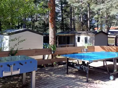 a ping pong table in a backyard with a trailer at Mobil home confortable avec terrasse à Sournia - API-1-52-319 in Sournia