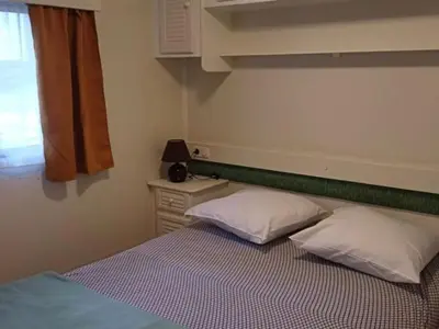 a bedroom with a bed with two pillows and a window at Mobil-home spacieux avec terrasse - 6 personnes - API-1-52-676 in Sournia