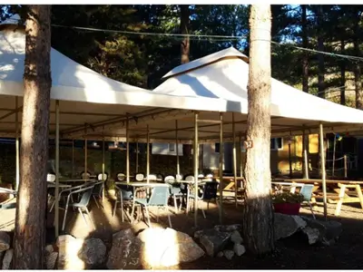 a patio with tables and chairs under a white umbrella at Mobil-home spacieux avec terrasse - 6 personnes - API-1-52-676 in Sournia