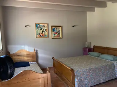 a bedroom with a bed and two pictures on the wall at Belle vue avec piscine sécurisée in Sainte-Camelle