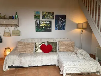 a living room with a couch with a heart pillow on it at Belle vue avec piscine sécurisée in Sainte-Camelle