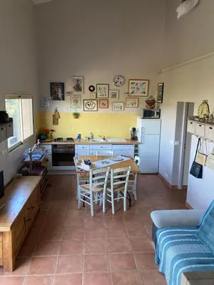 a kitchen with a table and chairs in a room at Belle vue avec piscine sécurisée in Sainte-Camelle