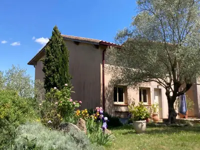 a small house with flowers in the yard at Belle vue avec piscine sécurisée in Sainte-Camelle