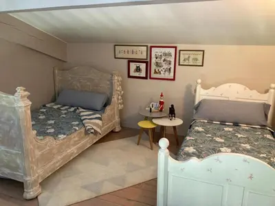 a childs bedroom with two beds and a table at Belle vue avec piscine sécurisée in Sainte-Camelle