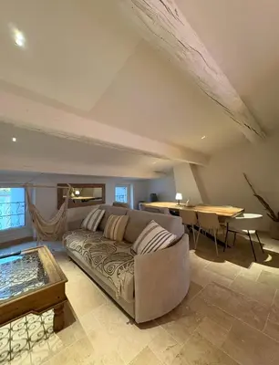 a living room with a couch and a table at Charmante maison rénovée au cœur du village de Gruissan in Gruissan