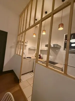 a kitchen with white cabinets and a large window at appartement lumineux cosy 4 couchages coeur de narbonne in Narbonne