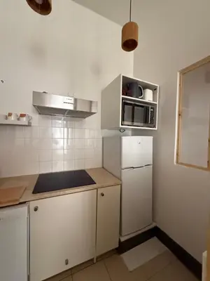 a kitchen with white cabinets and a microwave at appartement lumineux cosy 4 couchages coeur de narbonne in Narbonne