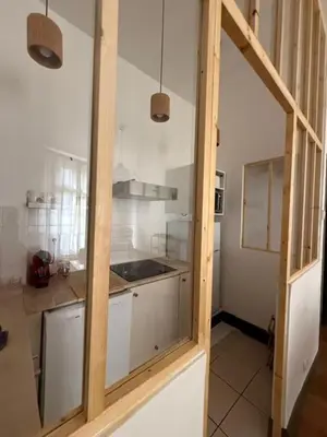 a kitchen with white cabinets and a glass door at appartement lumineux cosy 4 couchages coeur de narbonne in Narbonne