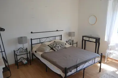 a bedroom with a bed and two tables and a mirror at La Maison de Pierre in Manses