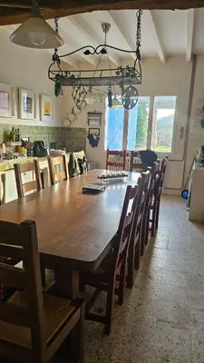 a dining room with a large wooden table and chairs at La Maison de Pierre in Manses