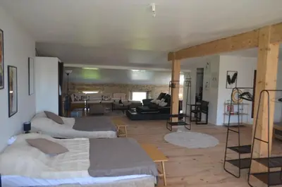 a room with two beds and a living room with a couch at La Maison de Pierre in Manses