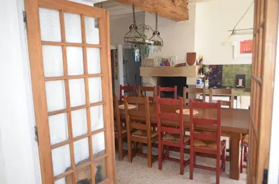 a dining room and kitchen with a table and chairs at La Maison de Pierre in Manses