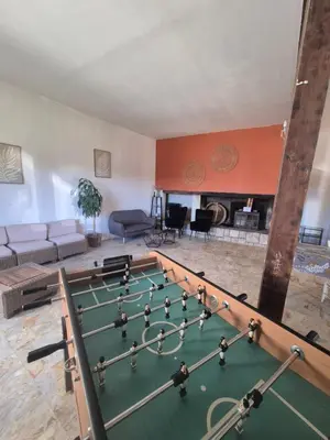 a living room with a pool table and a fireplace at La Maison de Pierre in Manses