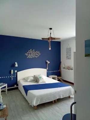 a blue bedroom with a bed and a blue wall at Chambre la plage in Limoux
