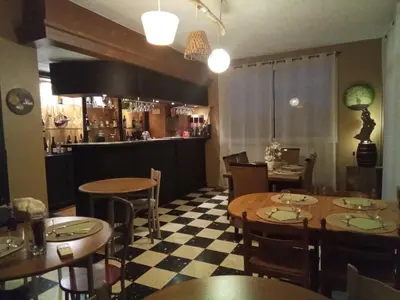 a restaurant with tables and chairs and a bar at Chambre la plage in Limoux