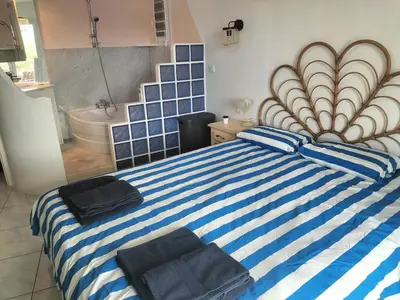 a bedroom with a blue and white striped bed with two towels at Entre mer et montagnes in Arboussols