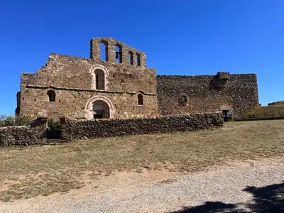 an old brick building with a tower on a hill at Entre mer et montagnes in Arboussols