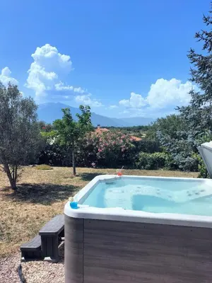 a jacuzzi tub in a yard with trees at Entre mer et montagnes in Arboussols