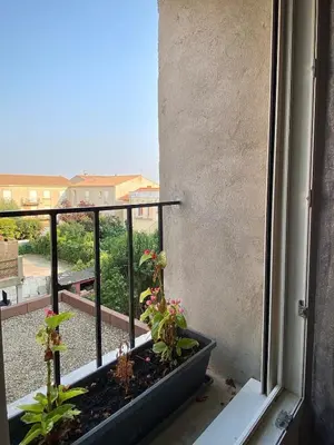 an open window with plants on a balcony at Two bed accommodation in Narbonne