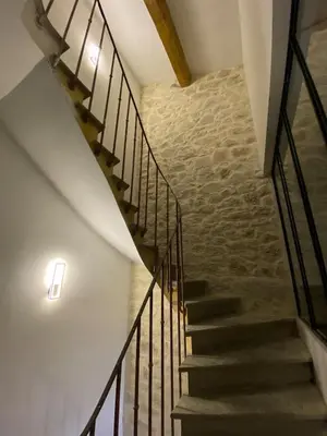 a staircase in a building with a stone wall at Two bed accommodation in Narbonne