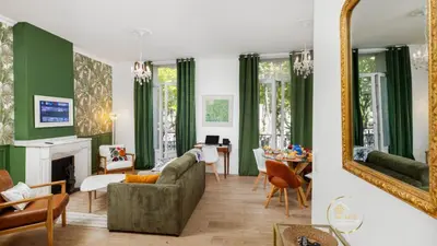 a living room with green walls and a mirror at Heart of Oc Mistral Elegant & Spacious Center Train Station in Narbonne