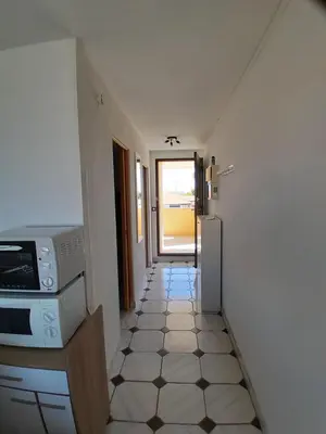 a hallway of a room with a kitchen and a floor at Petit appartement entre mer et montagne in Port-la-Nouvelle