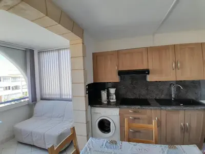 a kitchen with a sink and a washing machine at Petit appartement entre mer et montagne in Port-la-Nouvelle