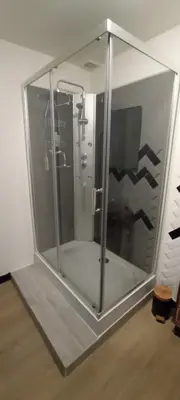 a shower in a glass box in a room at Chambres d'hôtes Las Carbounieros