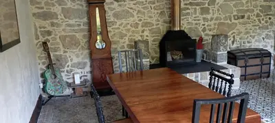 a room with a wooden table and a fireplace at Chambres d'hôtes Las Carbounieros