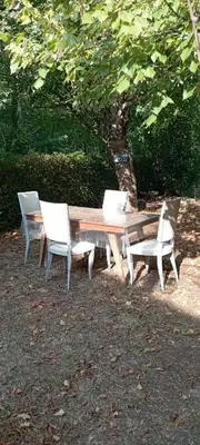 a wooden table and two chairs and a table and a table and chairs at Chambres d'hôtes Las Carbounieros