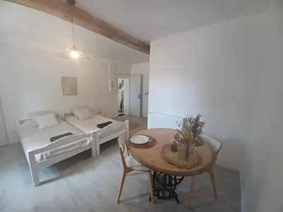 a bedroom with a bed and a table in a room at Studio Garrevaques Calme et Charme à la Campagne - Wendy in Garrevaques