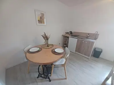 a table and chairs in a room with a kitchen at Studio Garrevaques Calme et Charme à la Campagne - Wendy in Garrevaques