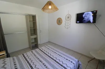 a bedroom with a bed and a tv on the wall at Villa l'Oranger in Sigean