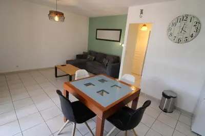 a living room with a table and chairs and a couch at Villa l'Oranger in Sigean