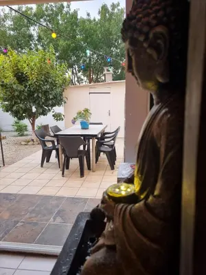 a statue in a yard with a table and chairs at Villa l'Oranger in Sigean