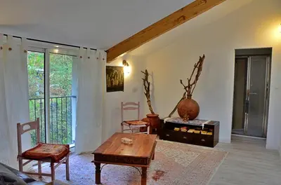 a living room with a wooden table and chairs at Violette in Saint-Pierre-de-Trivisy